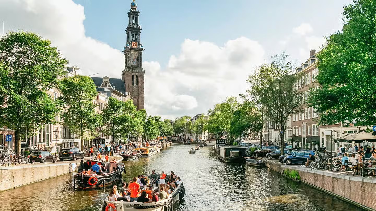 Canal d'Amsterdam bordé de maisons étroites et de vélos garés le long du quai